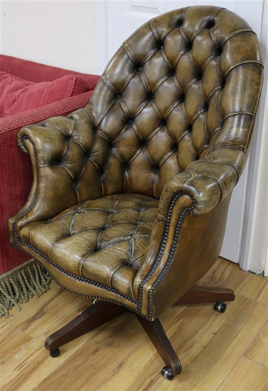 A swivel desk chair, upholstered in deep-buttoned tan hide
